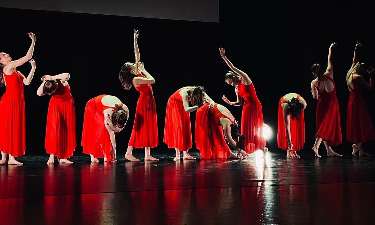 Danseelever i røde lange kjoler danser - Klikk for stort bilde